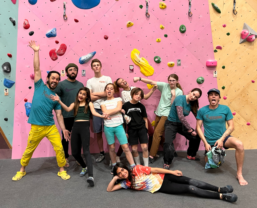 Kids and instructors posing together during a youth indoor rock climbing summer camp at Sessions Climbing + Fitness in El Paso
