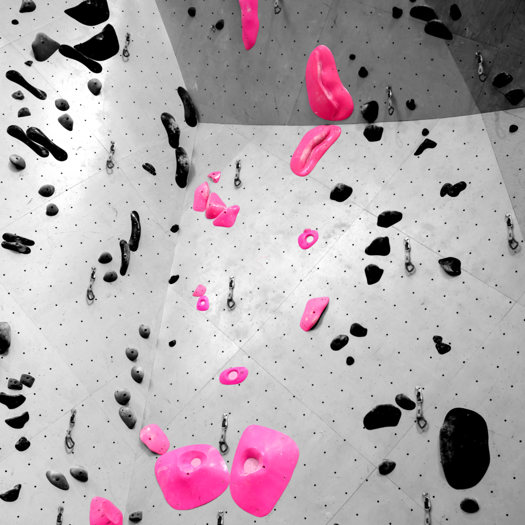Antoine’s pink 5.13+ bounty route highlighted in color against a black-and-white climbing wall on the main lead wall at Sessions Climbing + Fitness